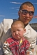 Image of Mongolian shopkeeper and his son, photographed on a motorbike.