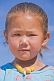 Image of Small Mongolian girl in a blue top and yellow beads.