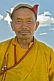 Image of Mongolian carpenter in hat and traditional yellow jacket.