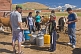 Mongolian villagers filling water cans from a communal hose.