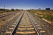 Railway tracks on the Indian Pacific route converge to the distant horizon.