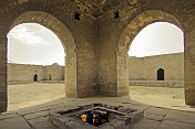 caption: Central fire pit and place of Zoroastrian worship at the Atesgah Fire Temple.