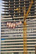Skyscraper under construction covered by a large poster.