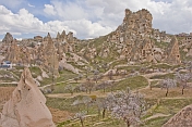 The dramatic rock castle dominates the blossomed valley of tuft dwellings.