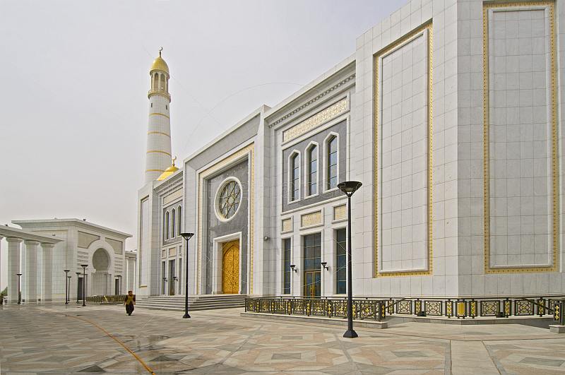 A solitary Turkmeni woman walks in front of the Ruhy Mosque, the biggest in Central Asia.