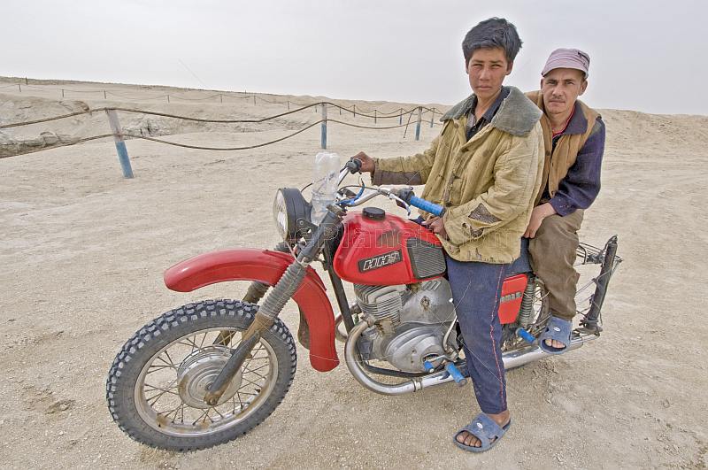 Two Turkman desert dwellers on a motorbike at the Darvaza Water Crater.