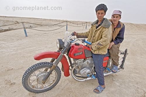 Two Turkman desert dwellers on a motorbike at the Darvaza Water Crater.
