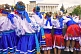 Ukrainian girls in national dress lean over a wall to watch the fun.