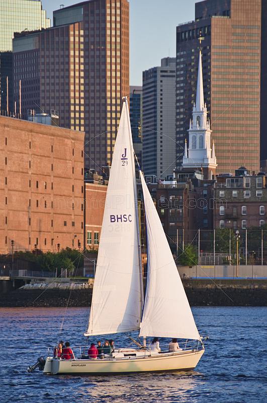J-Class boat 'Whiplash' sails through Boston harbor in late evening.