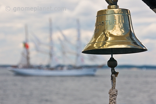 Ships bell of the barque 'Picton Castle' with tallship 'Sagres' in background.