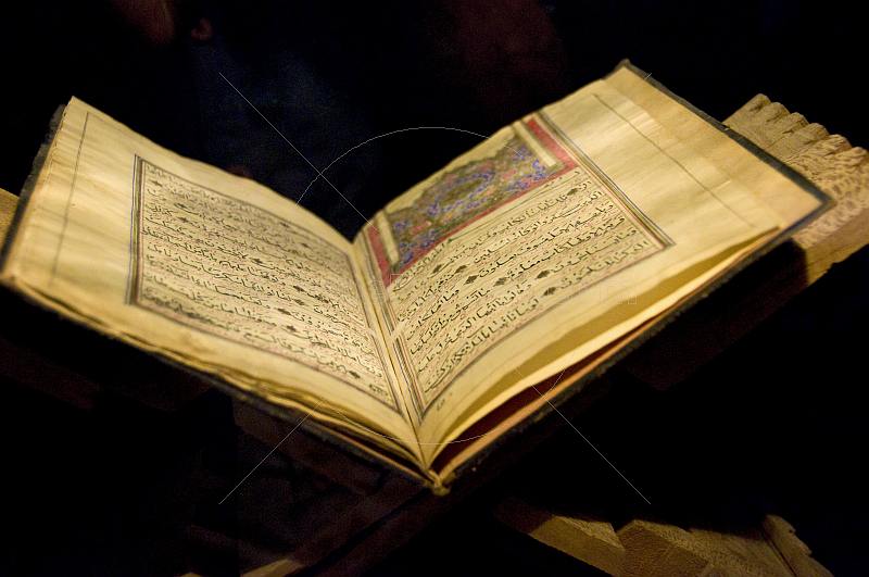 Pages of an ancient Koran, on a stand.