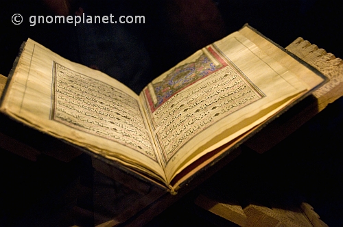 Pages of an ancient Koran, on a stand.