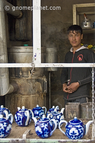 Young man at a tea stall in the Fergana Valley organises teapots as he waits for the water to boil.
