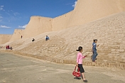 Schoolgirls walk in front of the city walls.