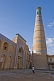 Image of A young girl walks to work past the minaret and madrassah of Islam-Khodja.