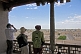 Image of Tourists view the ancient buildings of the Khiva skyline from the roof of the Kuhna Ark.