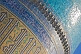 Image of Sunshine reflects off the luminous blue tilework on a dome of the Miri-Arab Madrassah.