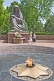 Two girls walk past the Crying Mother war memorial with eternal flame which honours the 400,000 Uzbek soldiers who died in WWII.