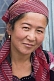 Image of Uzbek lady silk weaver in red headscarf.