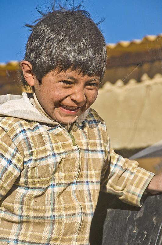 Laughing Bolivian boy in check jacket.