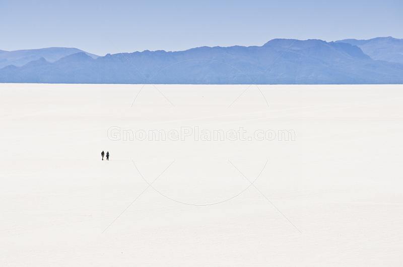 Couple walking on the Uyuni Salt Flats at Isla Pescado.