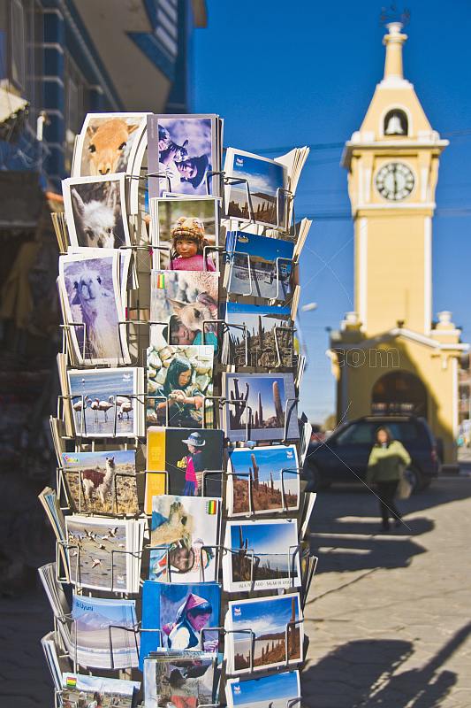 A rack of postcards with Clock Tower in the background.