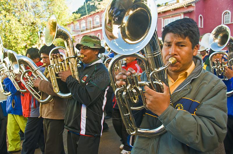 Euphonium players in a brass band marching through the streets in a traditional town festival.