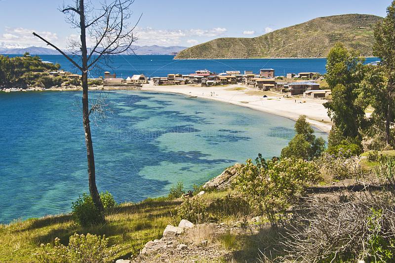 Beach houses and blue-water bay on the Isla del Sol in Lake Titicaca.