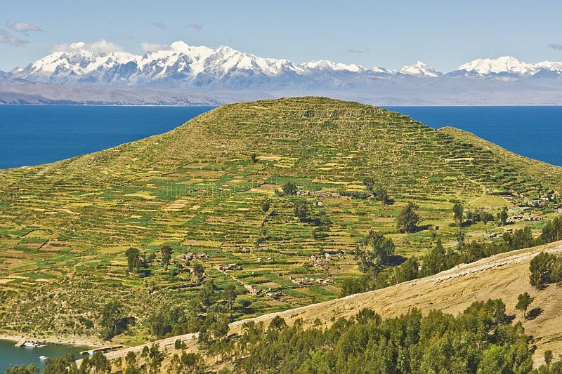 Terraced hillside on the Isla del Sol in Lake Titicaca with distant view of Andes mountains.