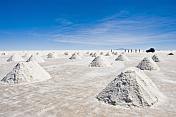 Jeep stops to view piles of salt ready for collection at the Uyuni Salt Flats.