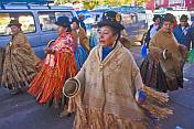 Women dancers walk through the streets in a traditional town festival.