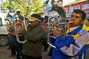 Euphonium players in a brass band marching through the streets in a traditional town festival.