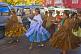 Women dancers walk through the streets in a traditional town festival.
