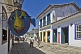 Image of Tourists walk along cobbled old town shopping street.