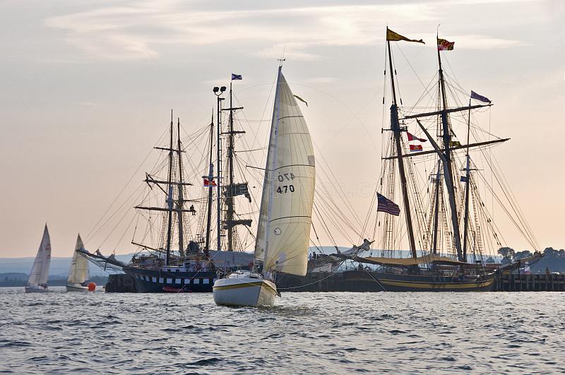 Yachts race past moored tallships in Pictou Harbour.