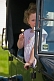 Small girl with lollipop and lilac dress waits in the back of a vintage Model T Ford car.
