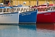 Image of Three white blue and red fishing boats moored to the wharf.