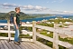 Image of Male hiker looks out over the town to the ocean forests and mountains.