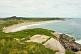 View over the grassy headland to beaches and forested hills at Sandbanks Provincial Park.