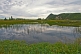 Image of Clouds and distant mountains reflected in the reed lake at Sandbanks Provincial Park.