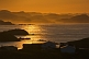 Image of Early morning sun lights the fishing village and distant islands across the ocean inlet.