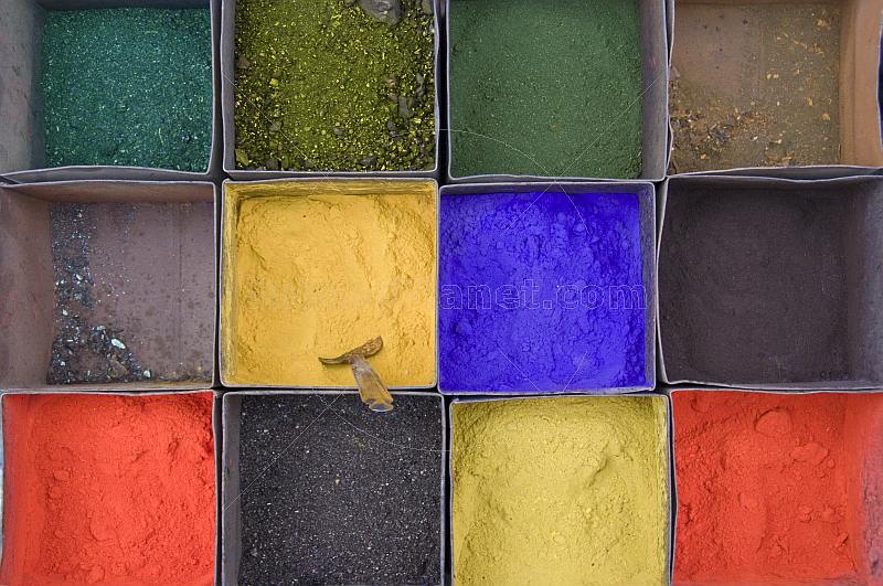 Colored powders in metal display-boxes.