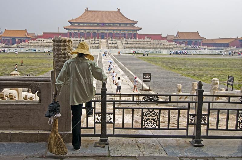 A cleaner watches tourists at the Hall of Supreme Harmony in the Forbidden City.