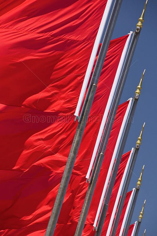 Red Chinese flags for the Peoples Republic of China billowing in the wind of Tiananmen Square.