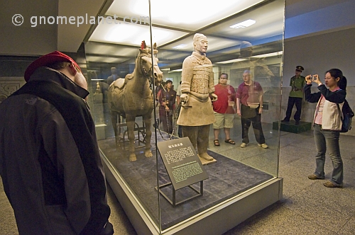 Chinese and Western visitors admire a Terracotta Soldier and horse.