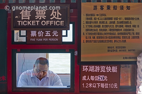 Chinese ticket seller in ticket office at Beihai Lake.