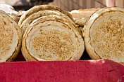 Bread stall with traditional Uighur circular bread loaves that have a flat base, used for eating meat stew.