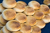 Bread buns with sesame seeds on a blue cloth.