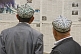 Image of Two Uighur men read the local-language newspapers.