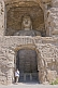 Image of Western woman looking at a giant Buddha statue at the Yungang Buddhist caves, near Datong.